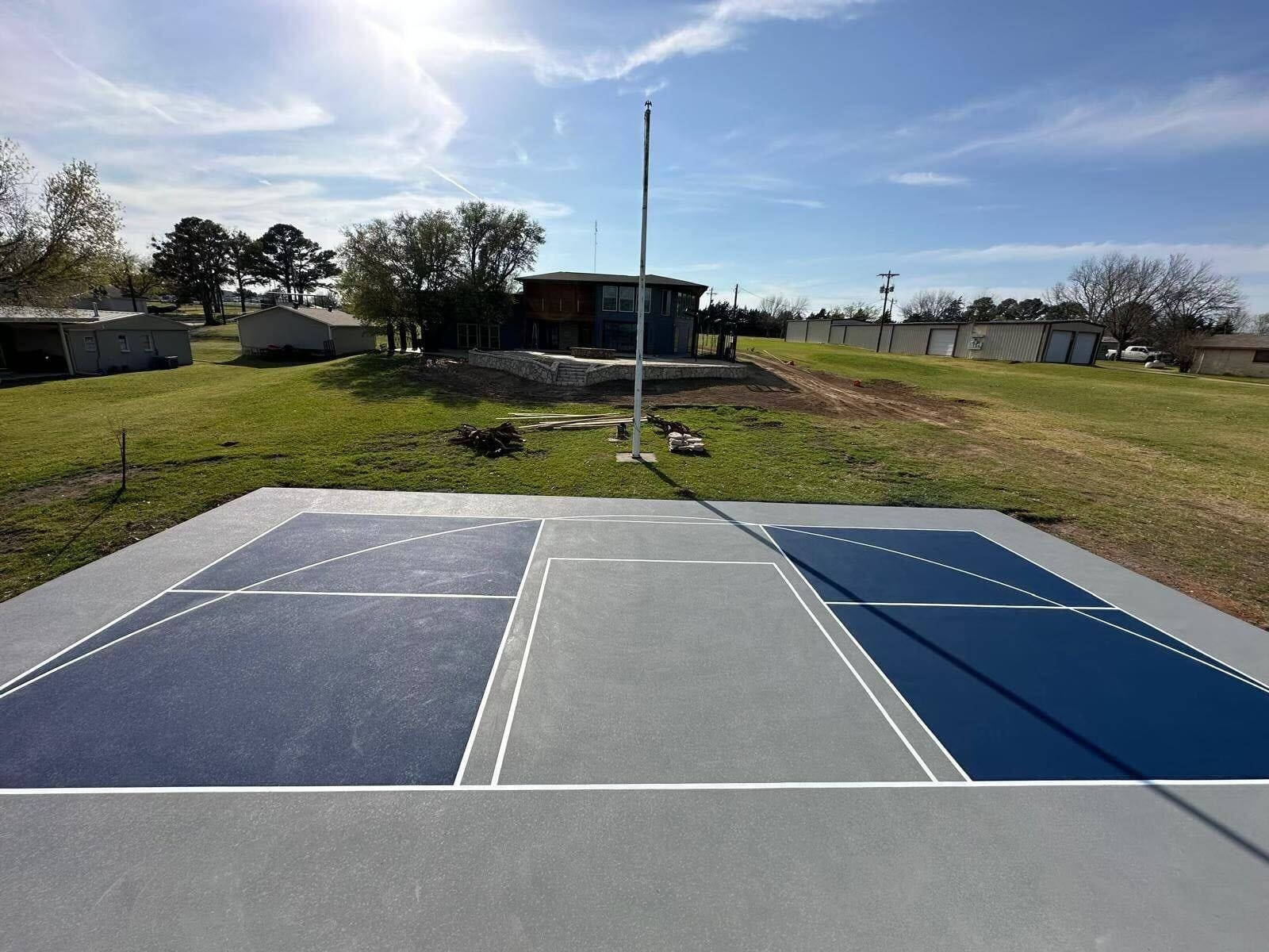 Multi-use court: a pickleball court in navy and gray with basketball lines on the same slab