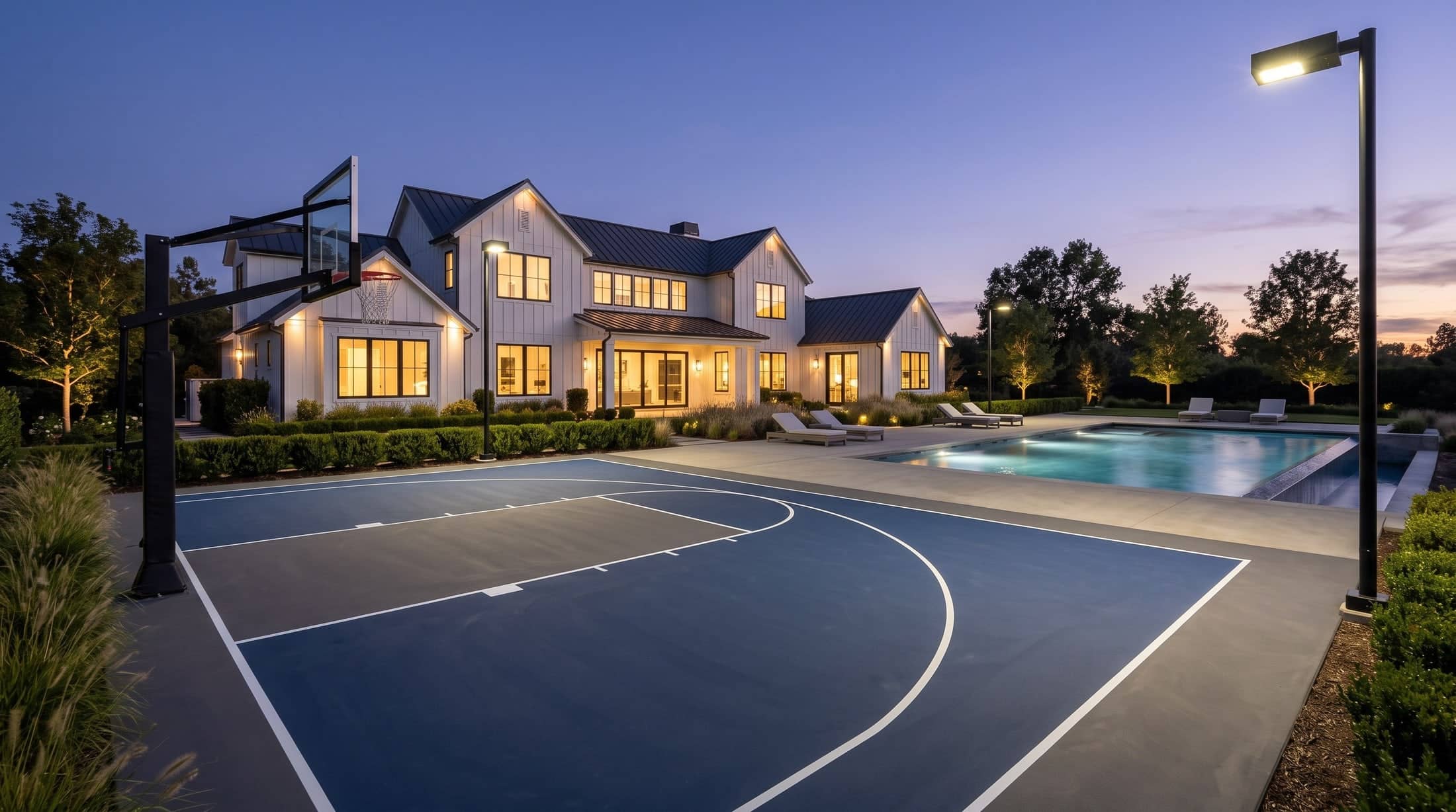 Multi-use court lit at night beside a pool